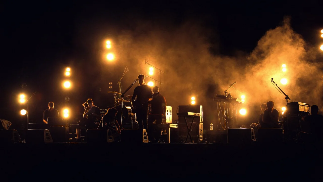 Des musiciens de sonorité[s] sur une scène baignée de fumée et de lumières dorées.