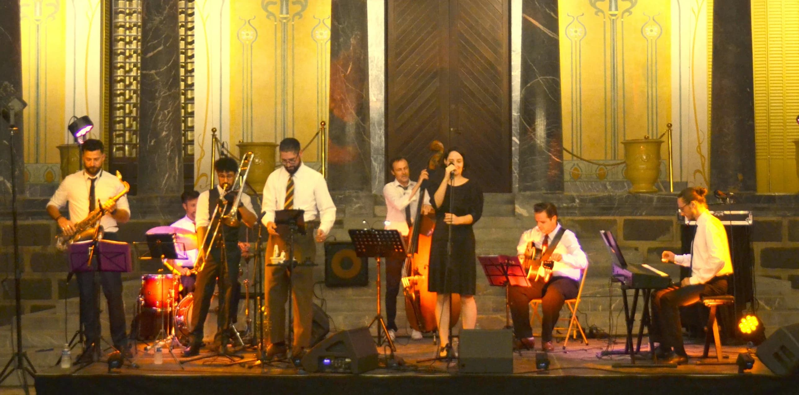 Le Belle Isle Swing Orchestra au complet sur la scène du Château Laurens, devant les colonnes de marbre et les décors Art nouveau.