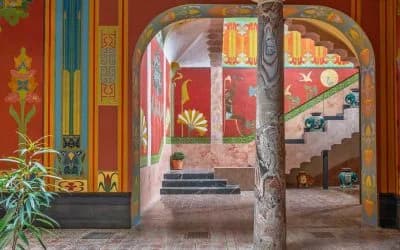 Un passage voûté du Château Laurens, aux murs peints de motifs Art nouveau rouges, verts et or.