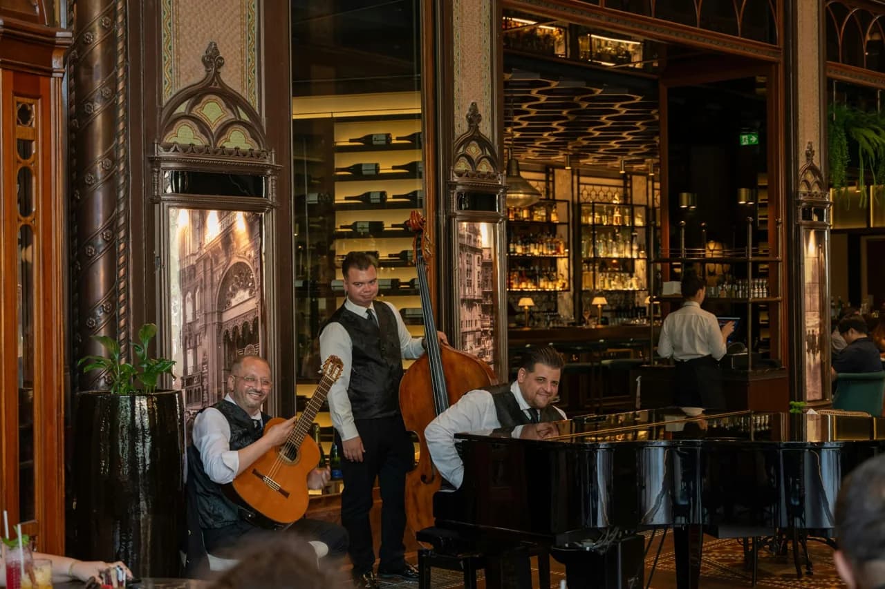 Un trio de jazz joue au piano, à la contrebasse et à la batterie dans un restaurant.