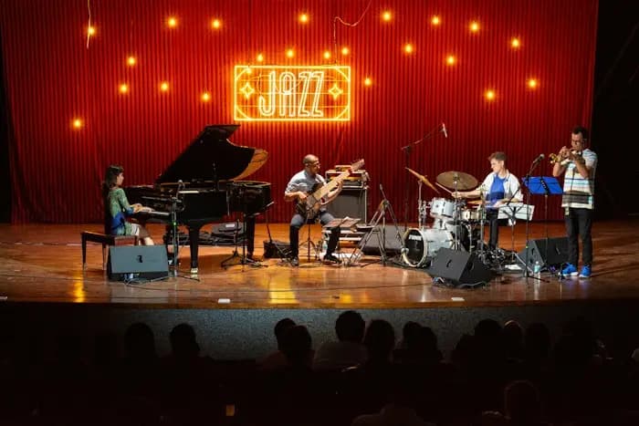 Une formation de jazz sur scène, devant un rideau rouge